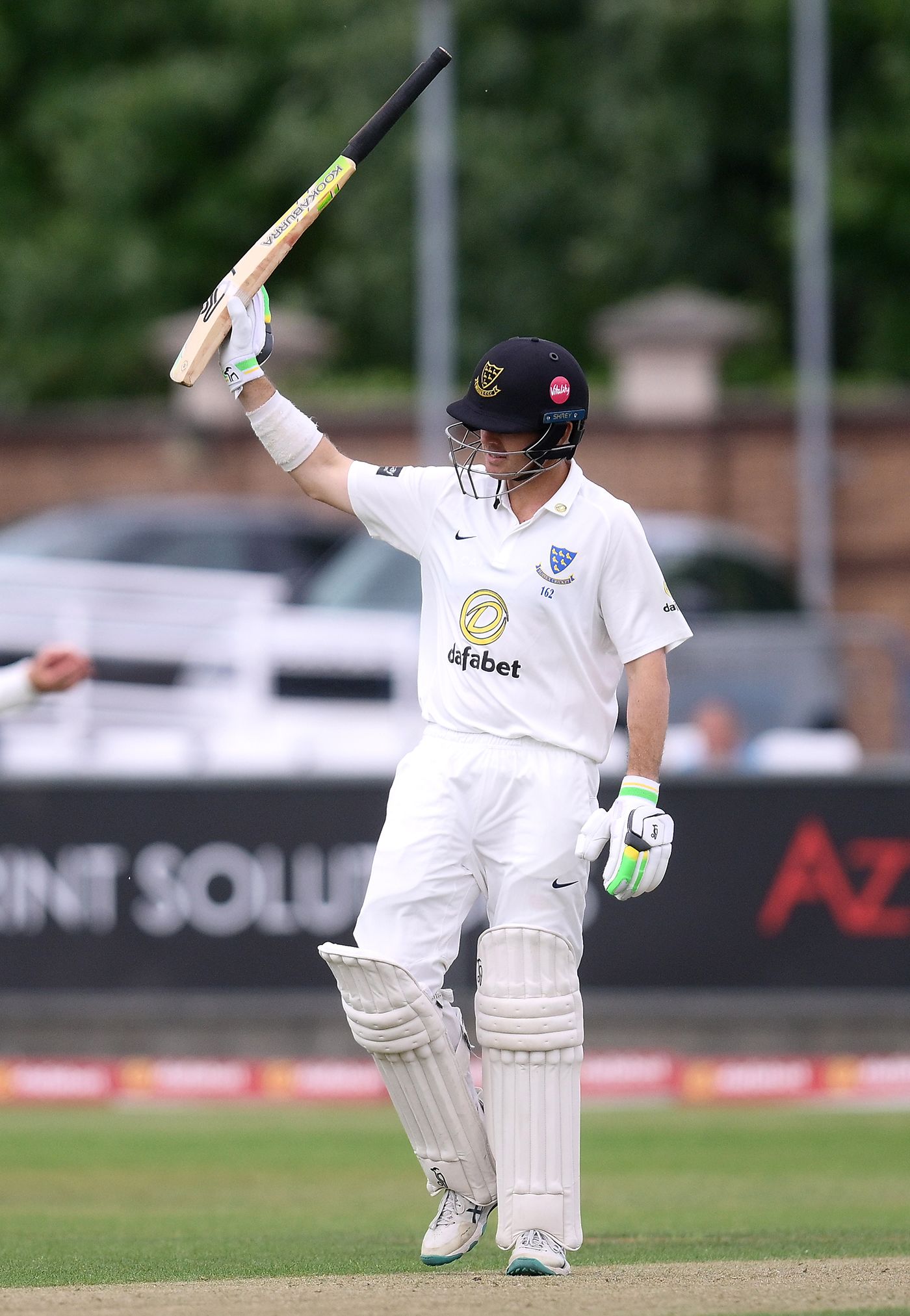 Daniel Hughes raises his bat on reaching fifty