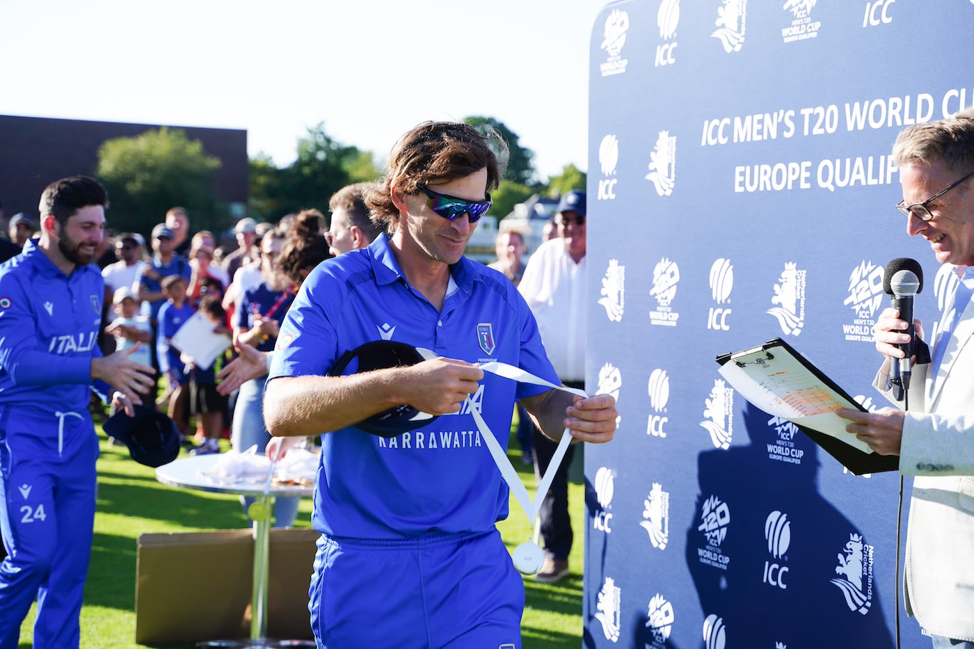 Joe Burns, the Italy captain, admires his medal