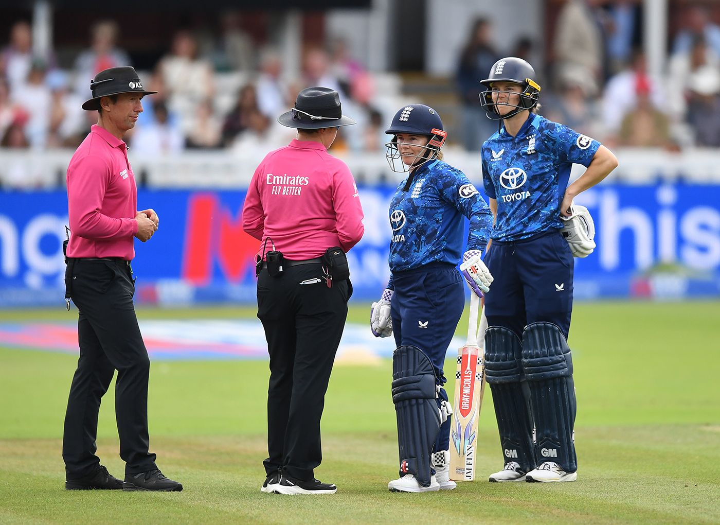 The umpires speak to Tammy Beaumont after reviewing for obstructing the field
