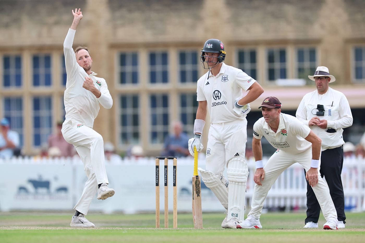 Tom Hartley bowls as Ben Charlesworth and James Anderson look on