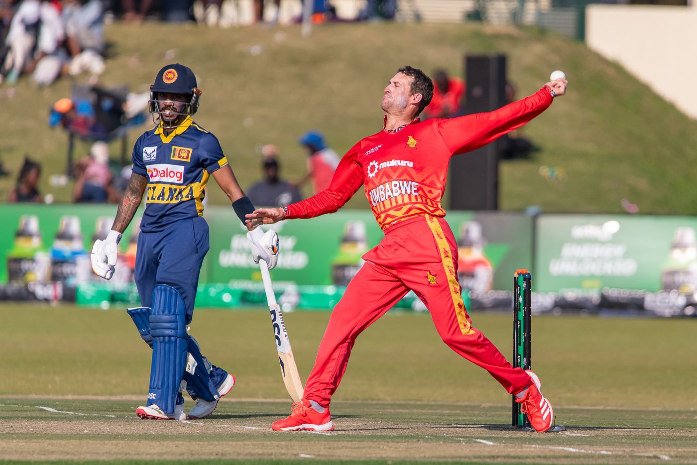 Sean Williams delivers a ball while Pathum Nissanka watches on