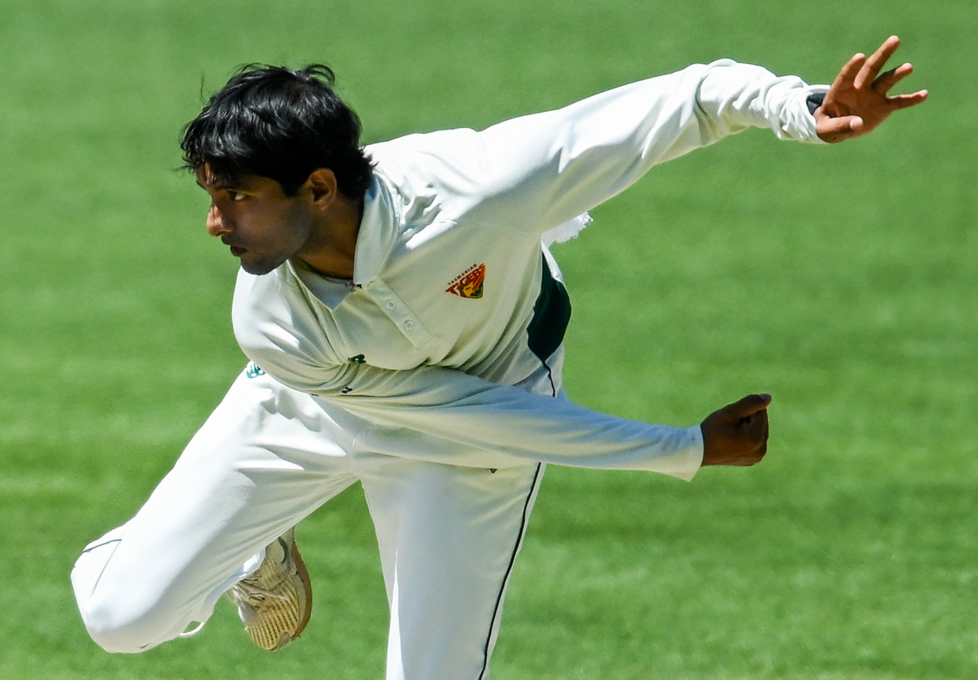 Nivethan Radhakrishnan in his offspin delivery stride