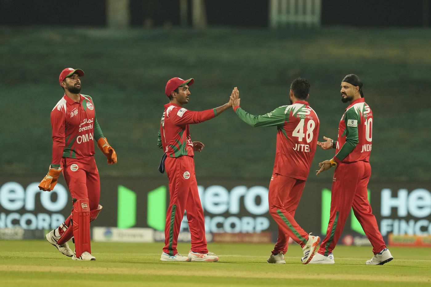 The Oman fielders celebrate the fall of a wicket