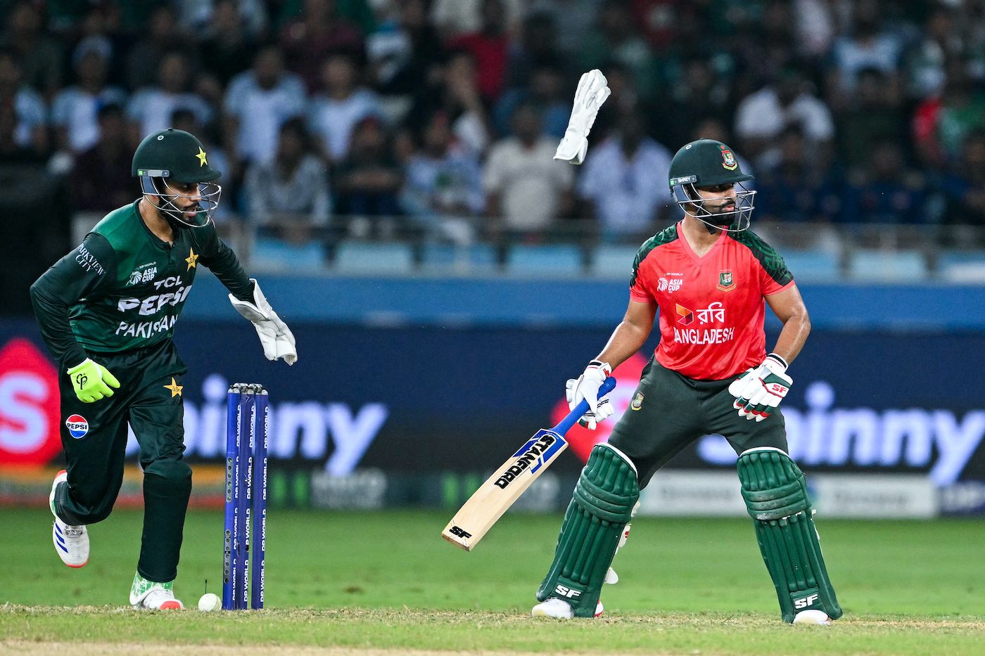 Mohammad Haris pops out his glove to gather the ball