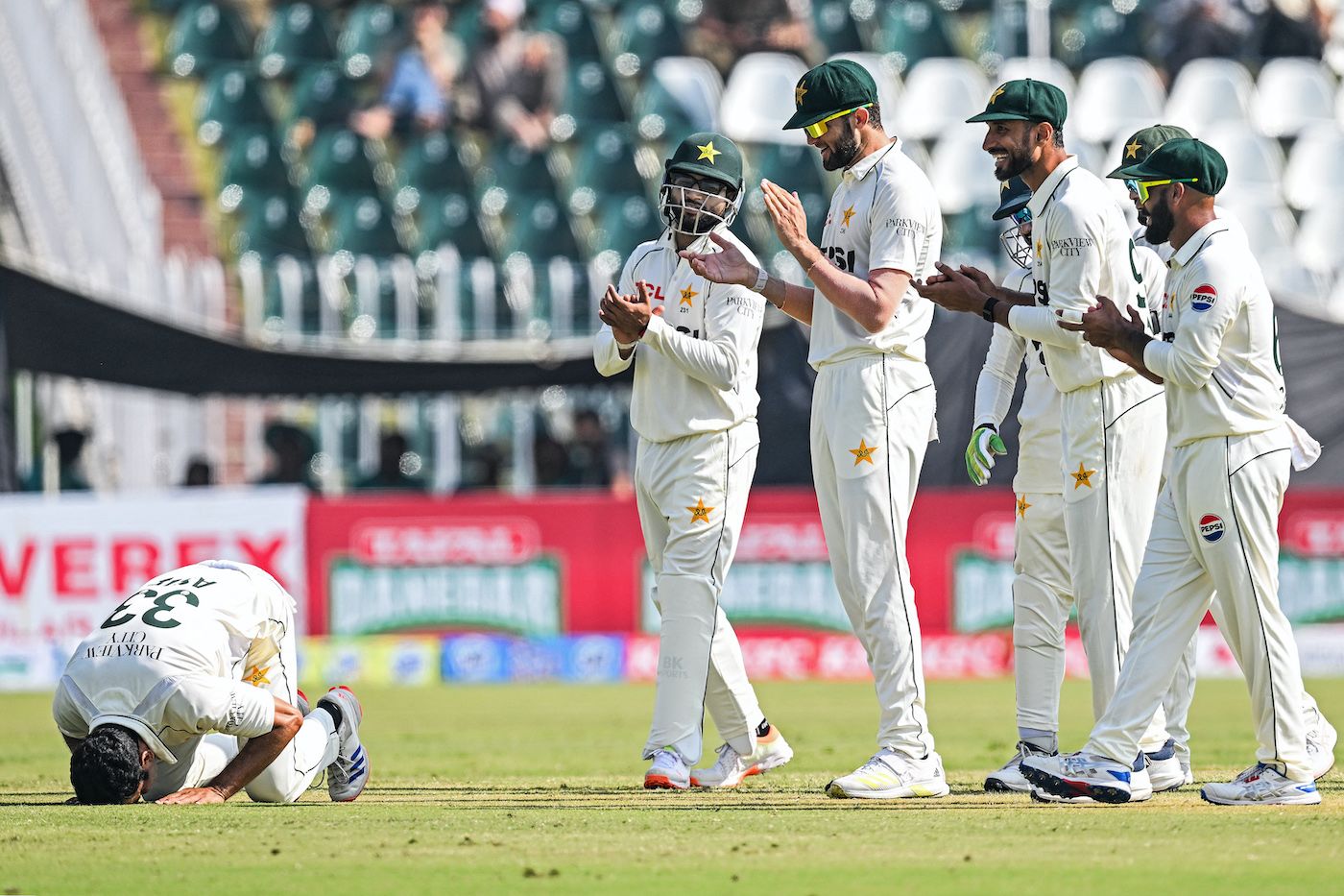 Team-mates watch Asif Afridi as he celebrates his five-for