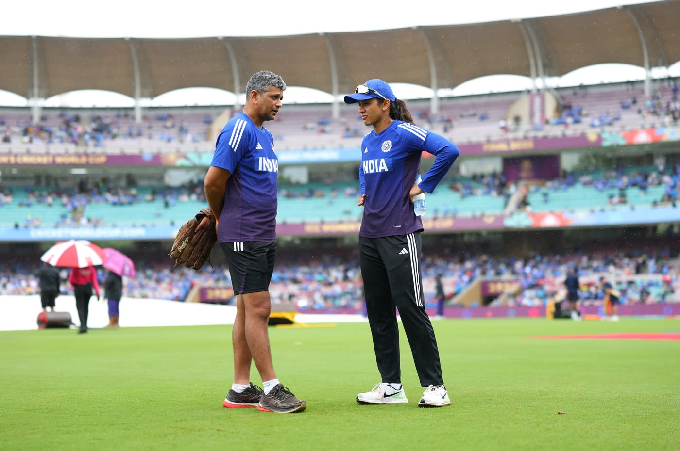 Head coach Amol Muzumdar and vice-captain Smriti Mandhana chat while it drizzles