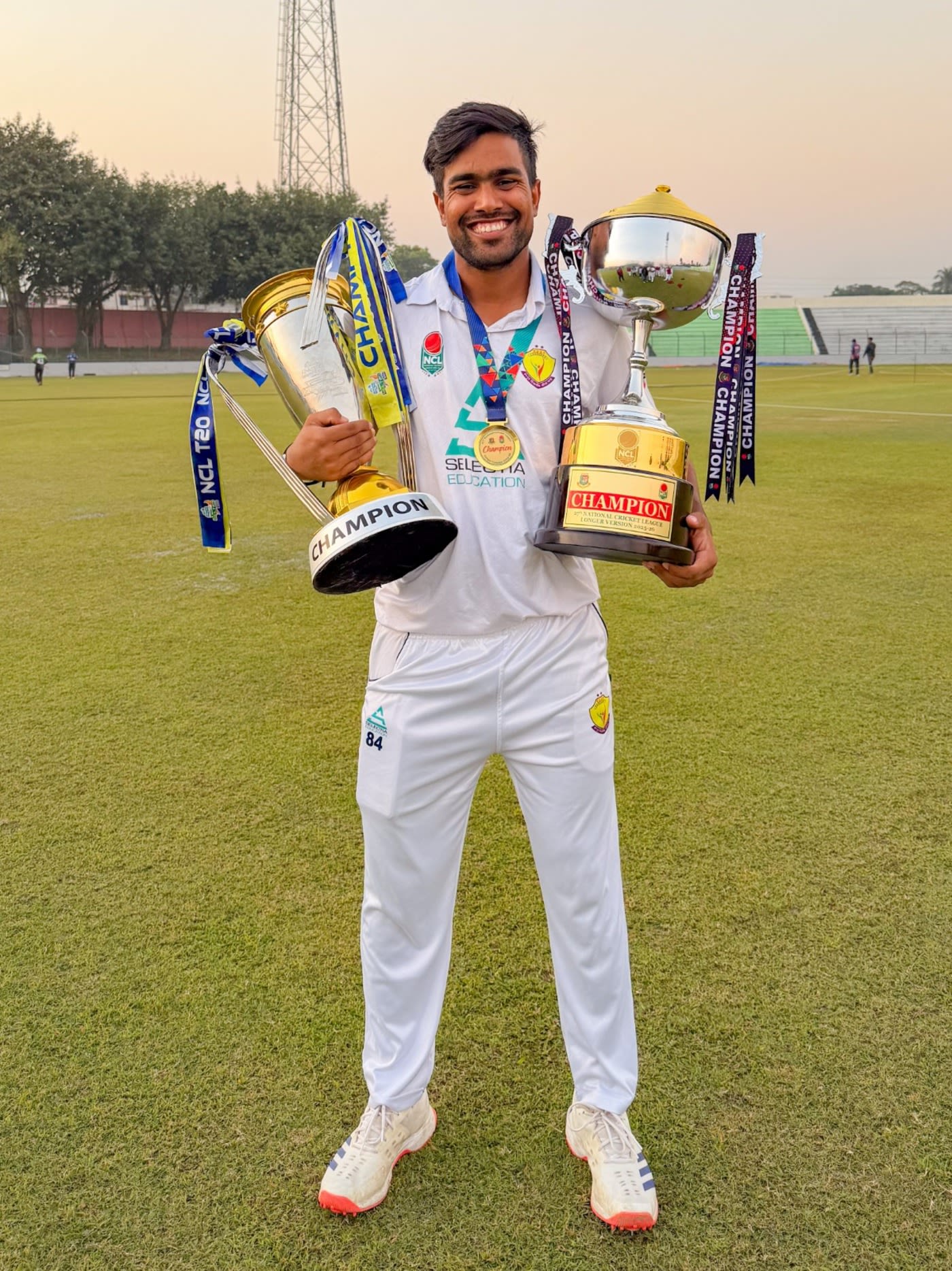 Akbar Ali with both NCL T20 and first-class trophies
