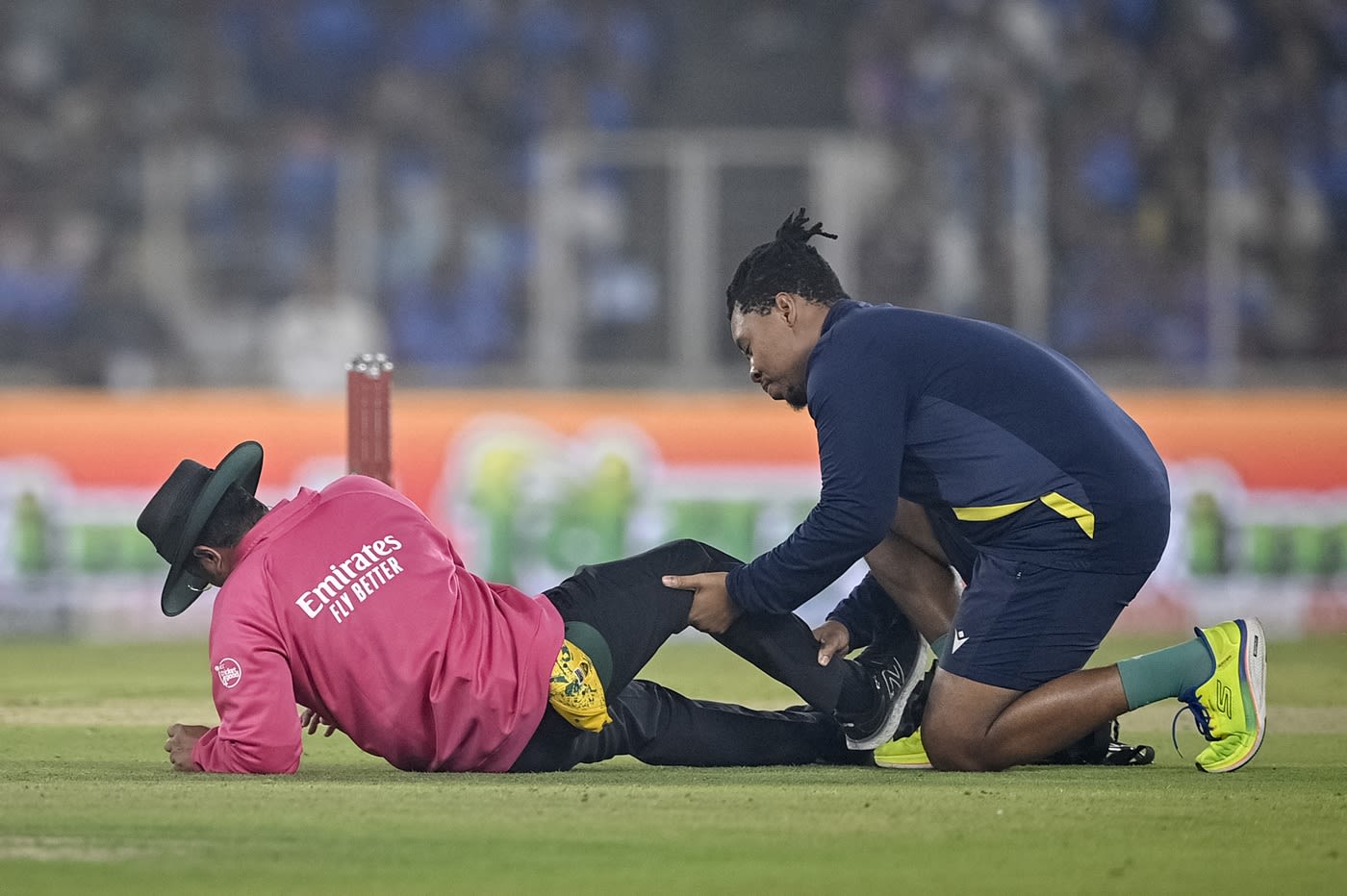 Umpire Rohan Pandit gets some attention from South Africa's physio after taking a blow to his shin