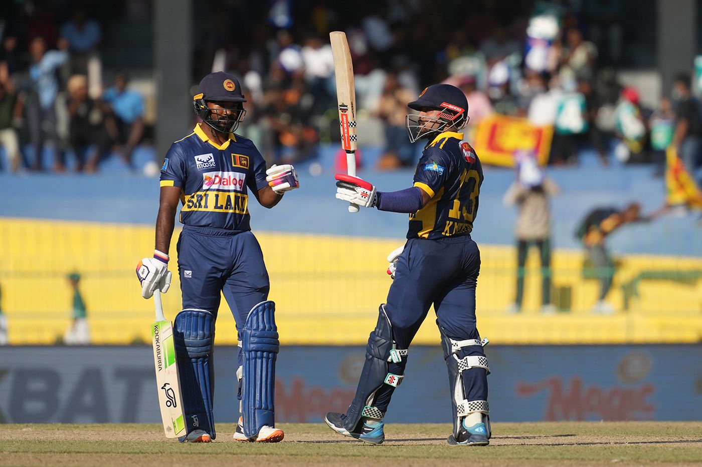 Kusal Mendis raises his bat on reaching fifty