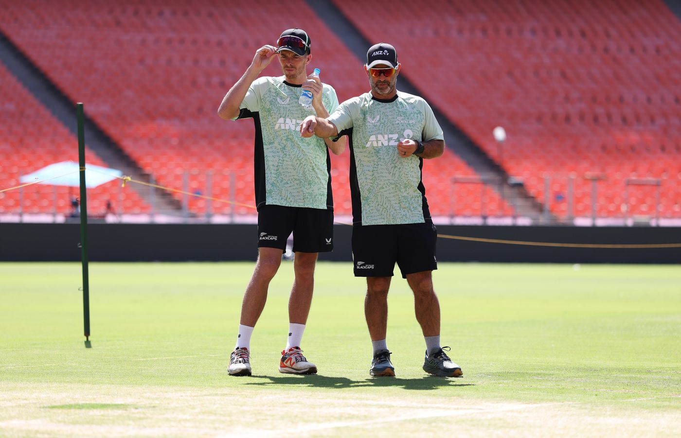 Captain Mitchell Santner and coach Rob Walter talk in the middle