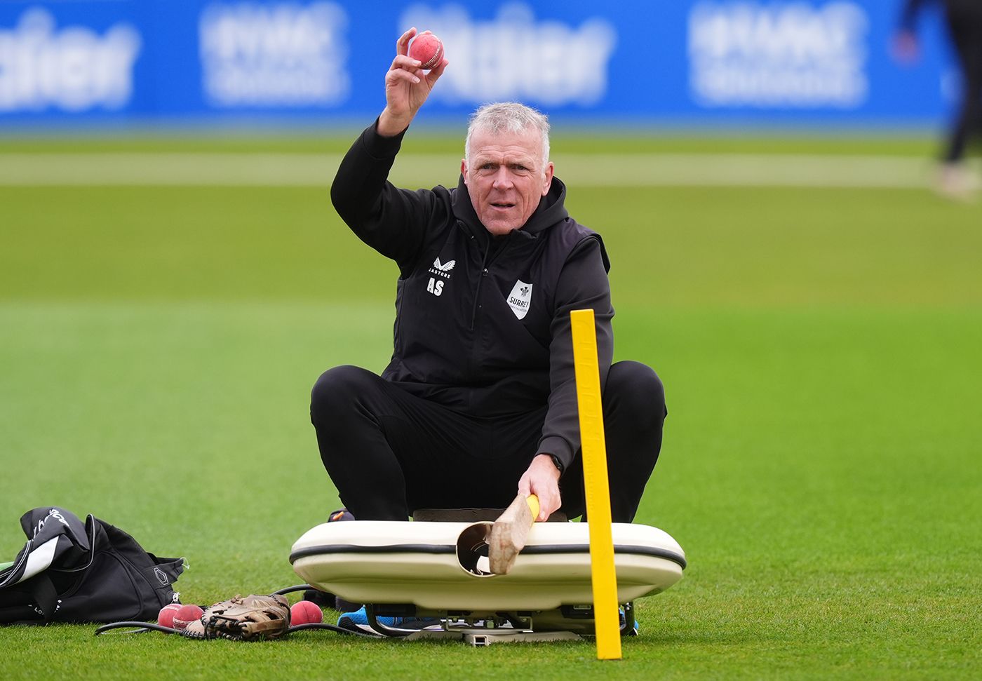 Alec Stewart feeds the ball machine before play