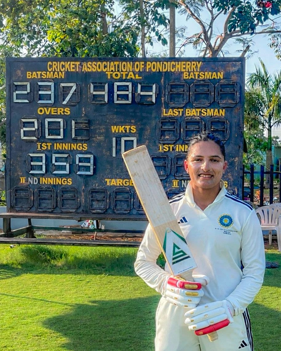 Sushma Verma poses next to the scoreboard after her double-hundred