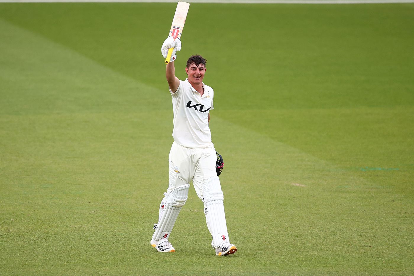 Adam Thomas celebrates after scoring a century on debut