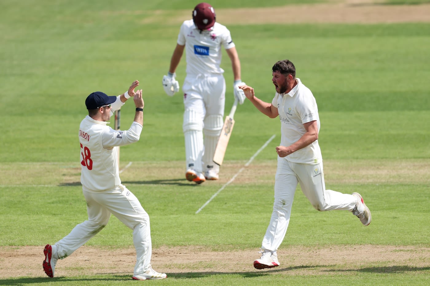 Tom Norton celebrates after taking his maiden first-class wicket