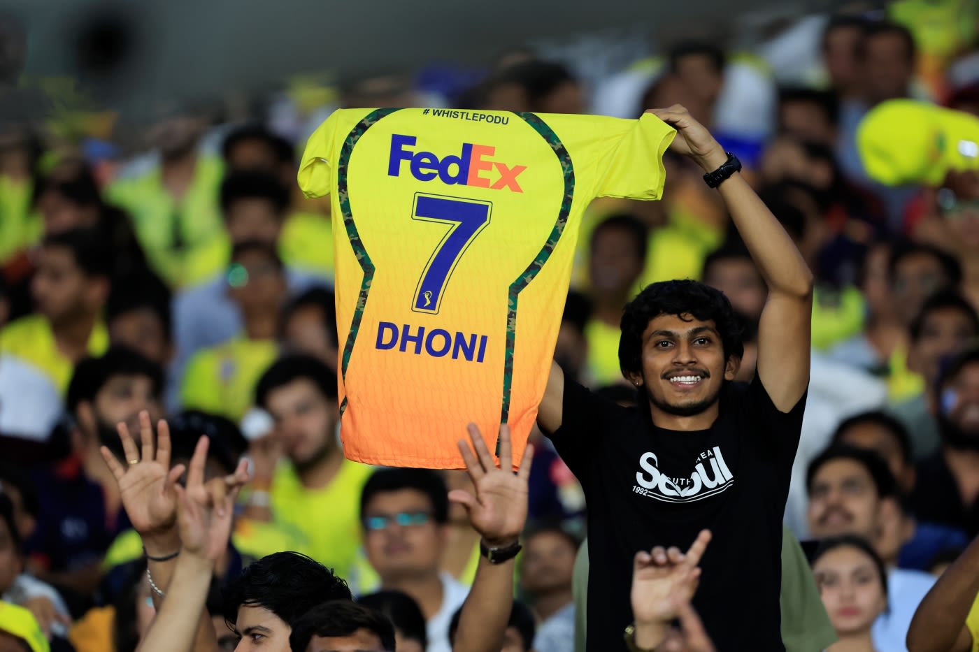 A fan holds up an MS Dhoni jersey