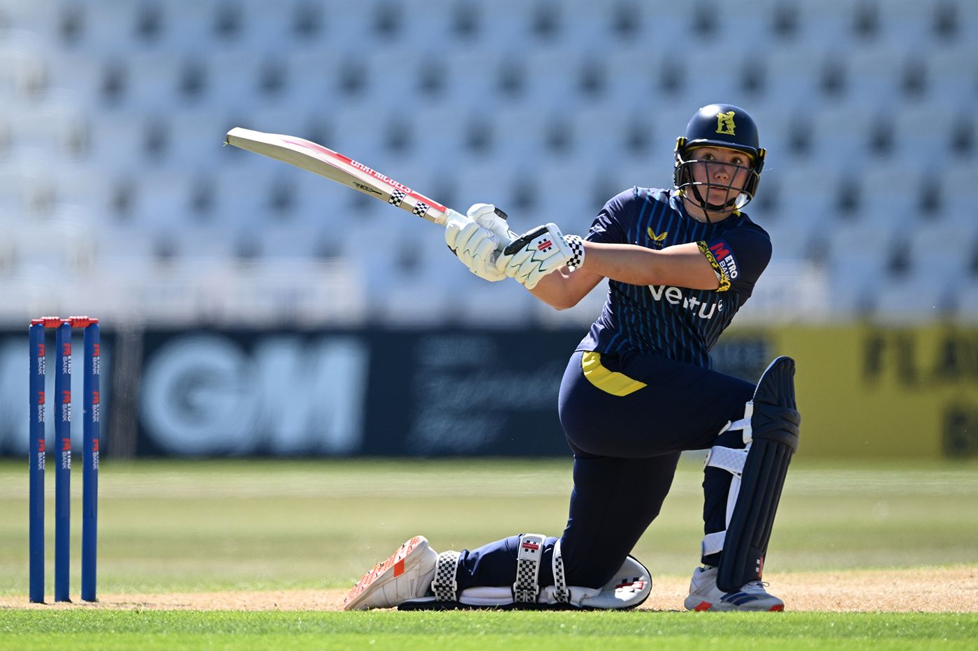 Katie George reverse-sweeps during her innings of 98
