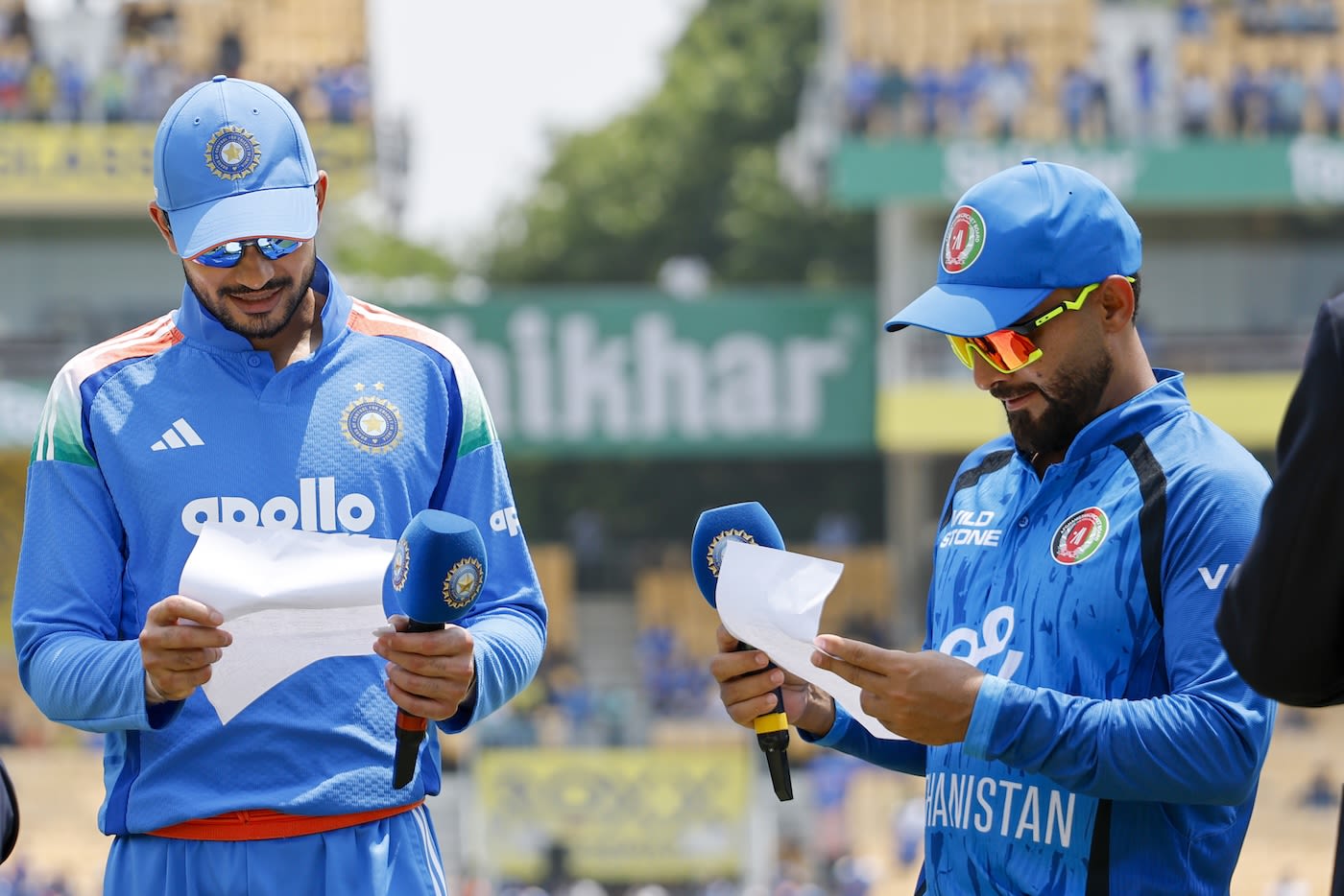 Shubman Gill and Hashmatullah Shahidi look at the team sheets - the teams made seven changes between them