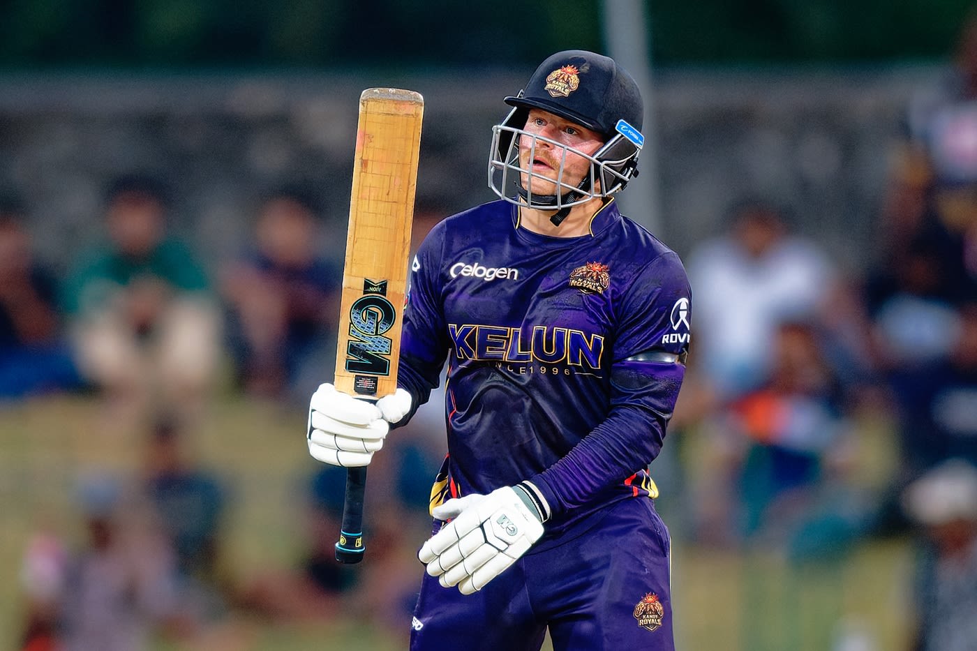 Dale Phillips raises his bat after reaching a half-century