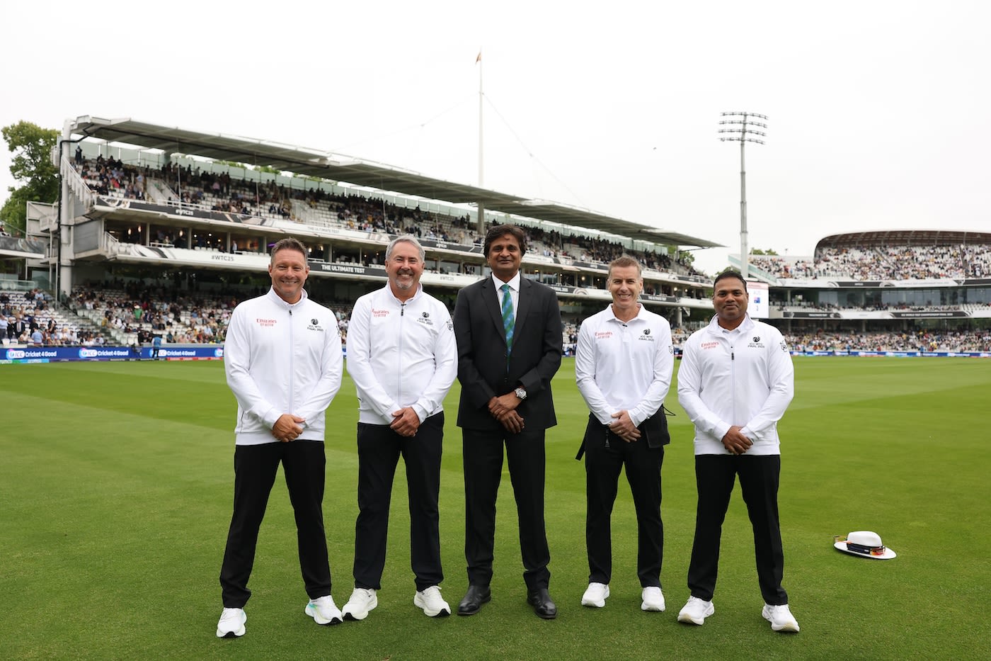 The umpires and referee line up before the start of play