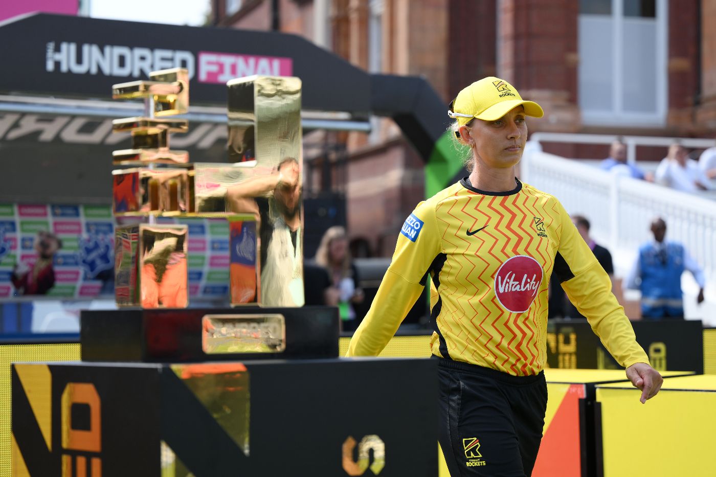 Ash Gardner walks past the Hundred trophy