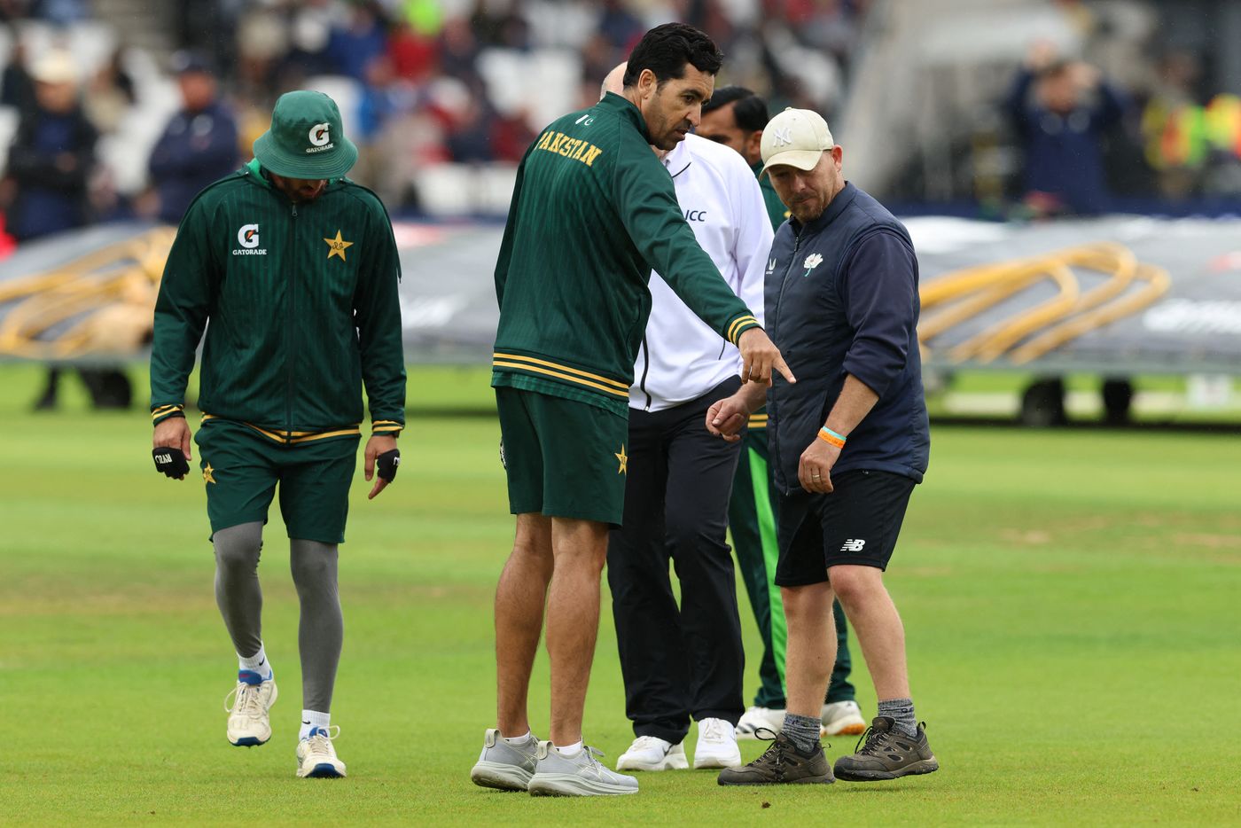 Umar Gul points out a wet spot on the outfield