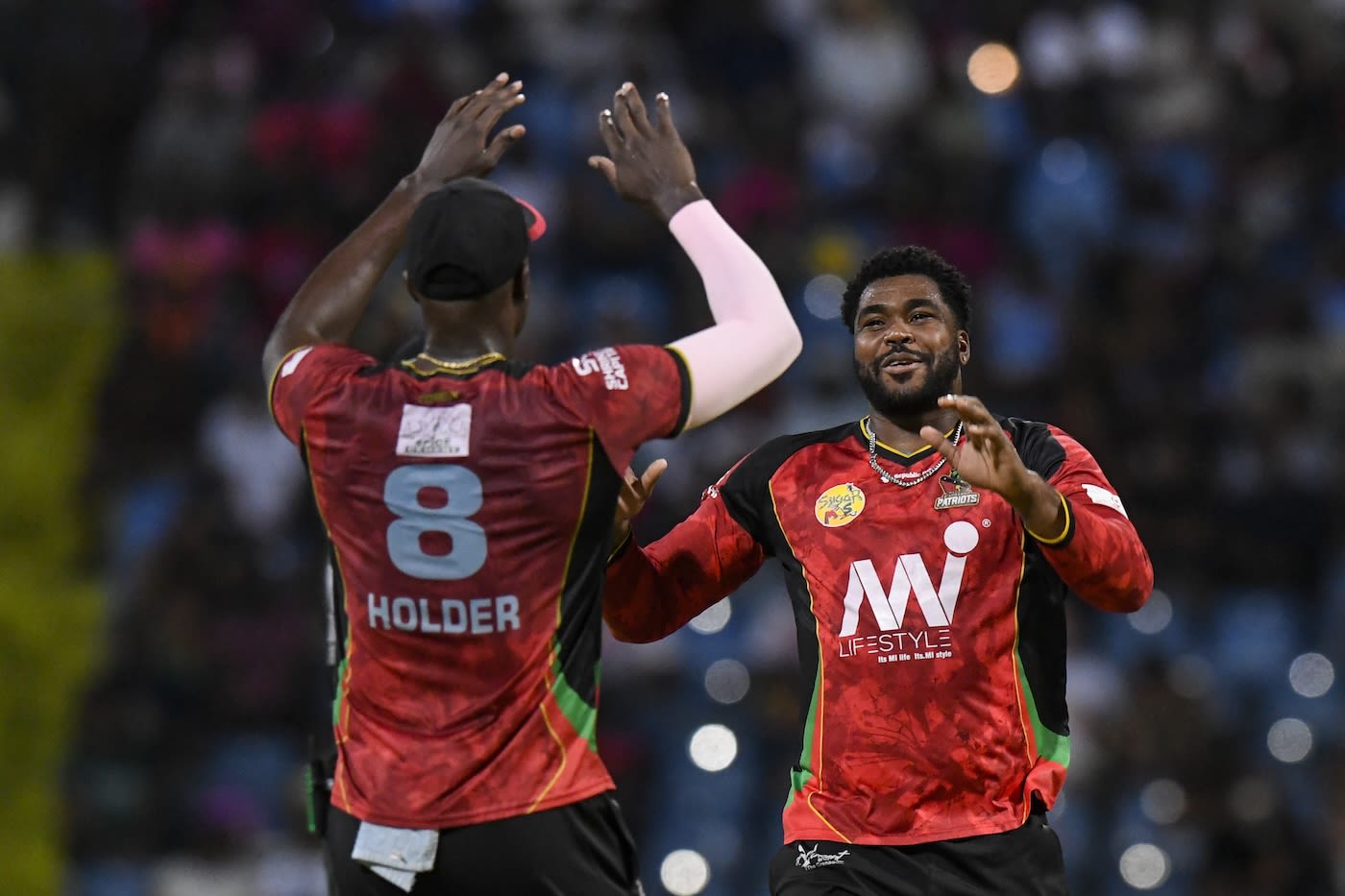 Obed McCoy celebrates a wicket with Jason Holder