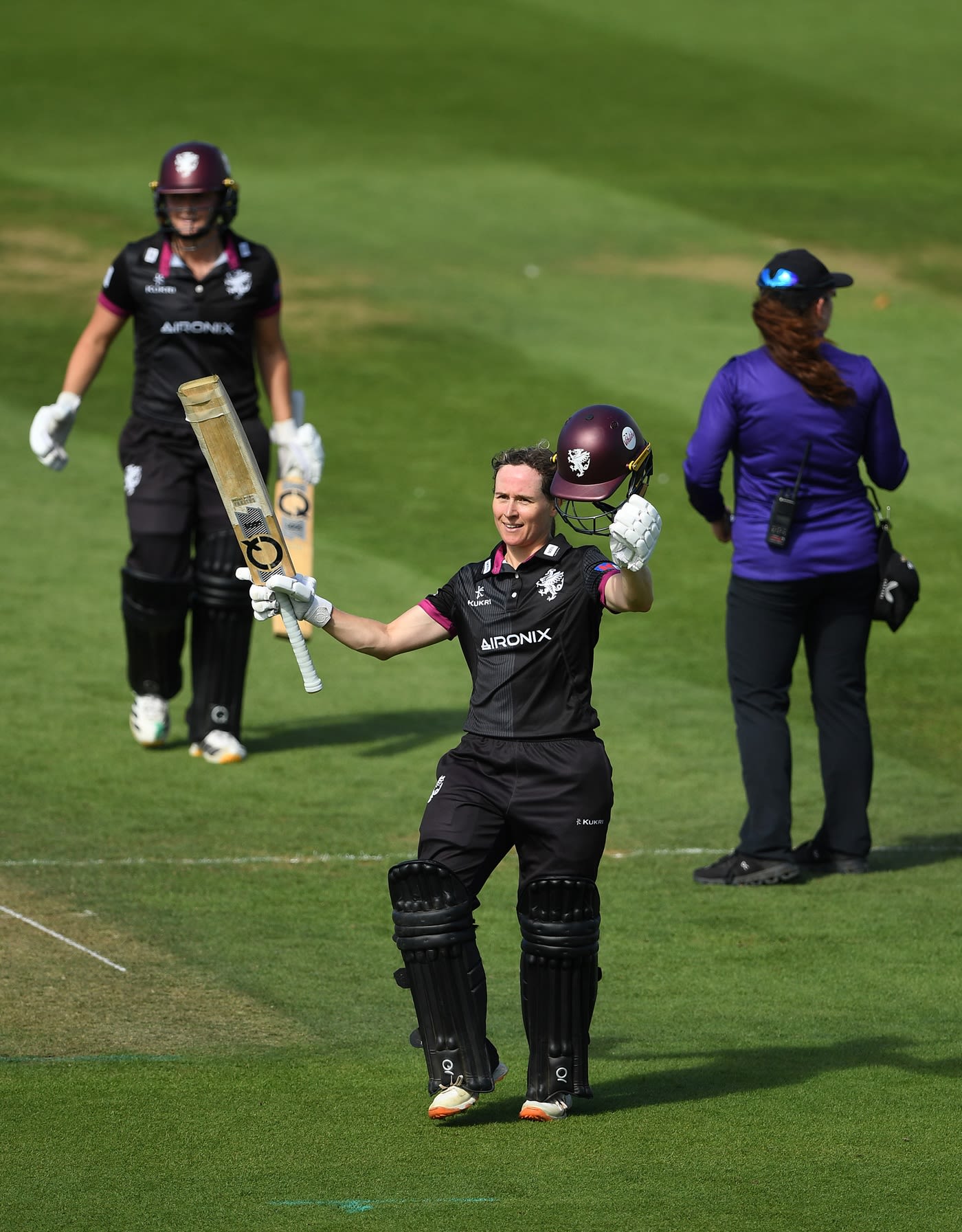 Sophie Luff raises her bat for a century