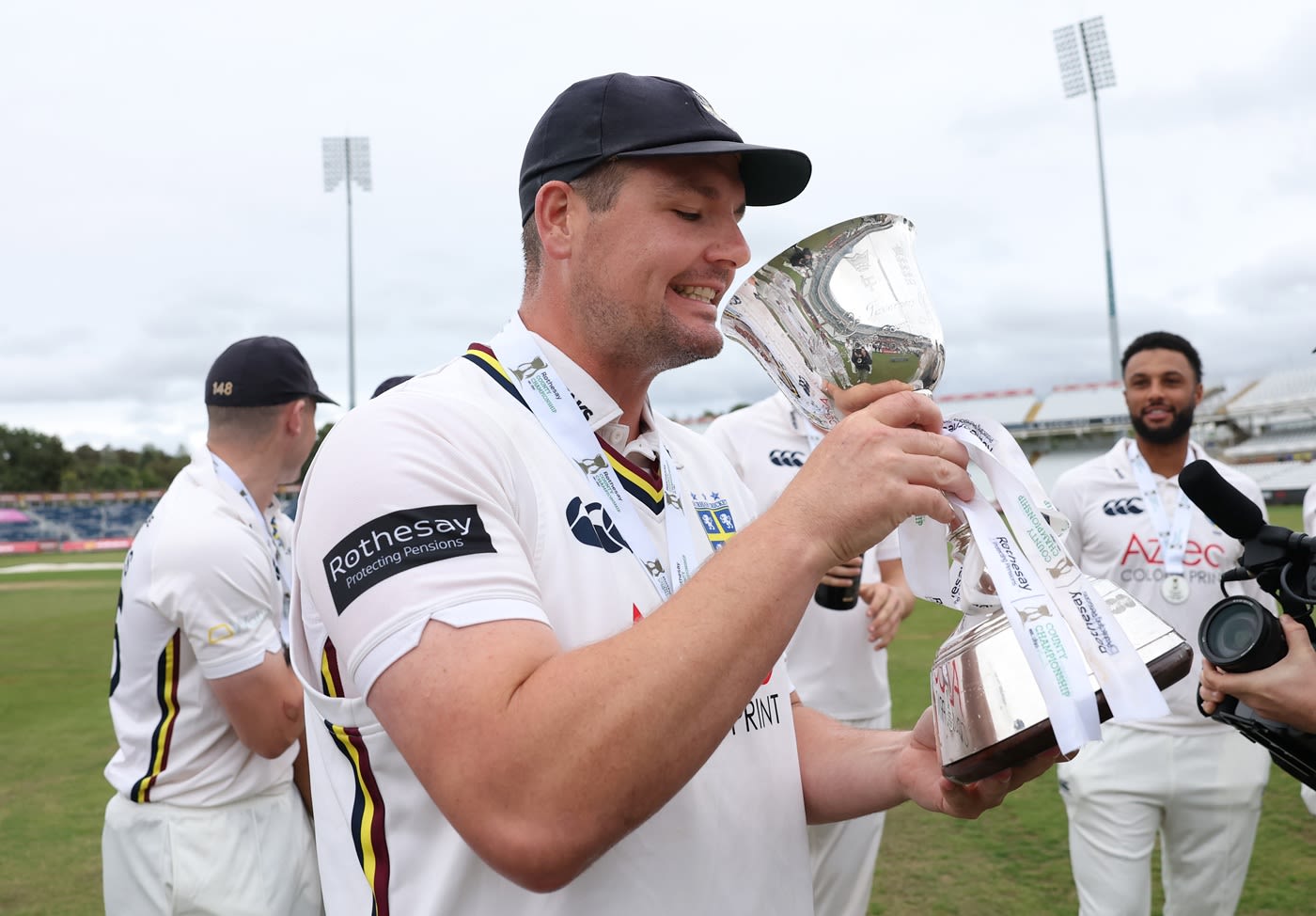 Alex Lees drinks from the Division Two trophy
