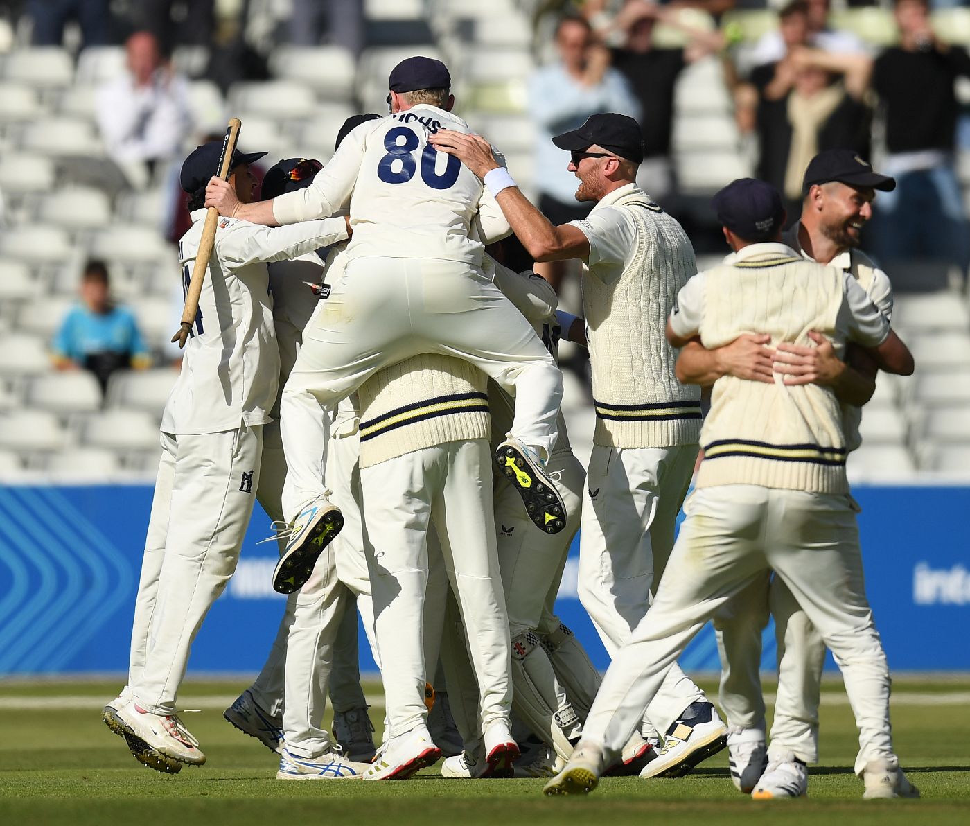 Warwickshire's players pile into the celebrations after Leicestershire's final wicket falls