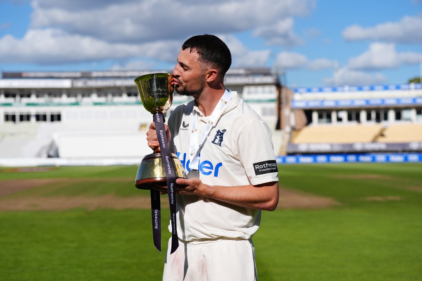 Ed Barnard kisses the County Championship title after Warwickshire's win