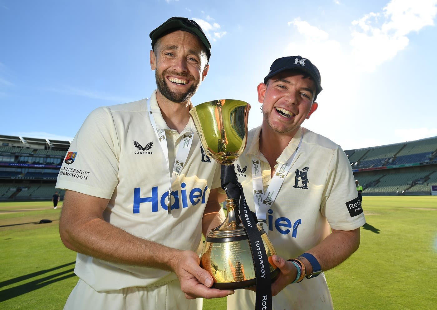Chris Woakes and Ethan Bamber pose with the County Championship trophy