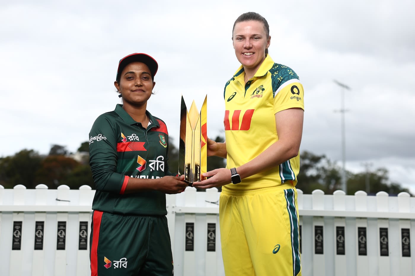 Nigar Sultana and Tahlia McGrath pose with the trophy