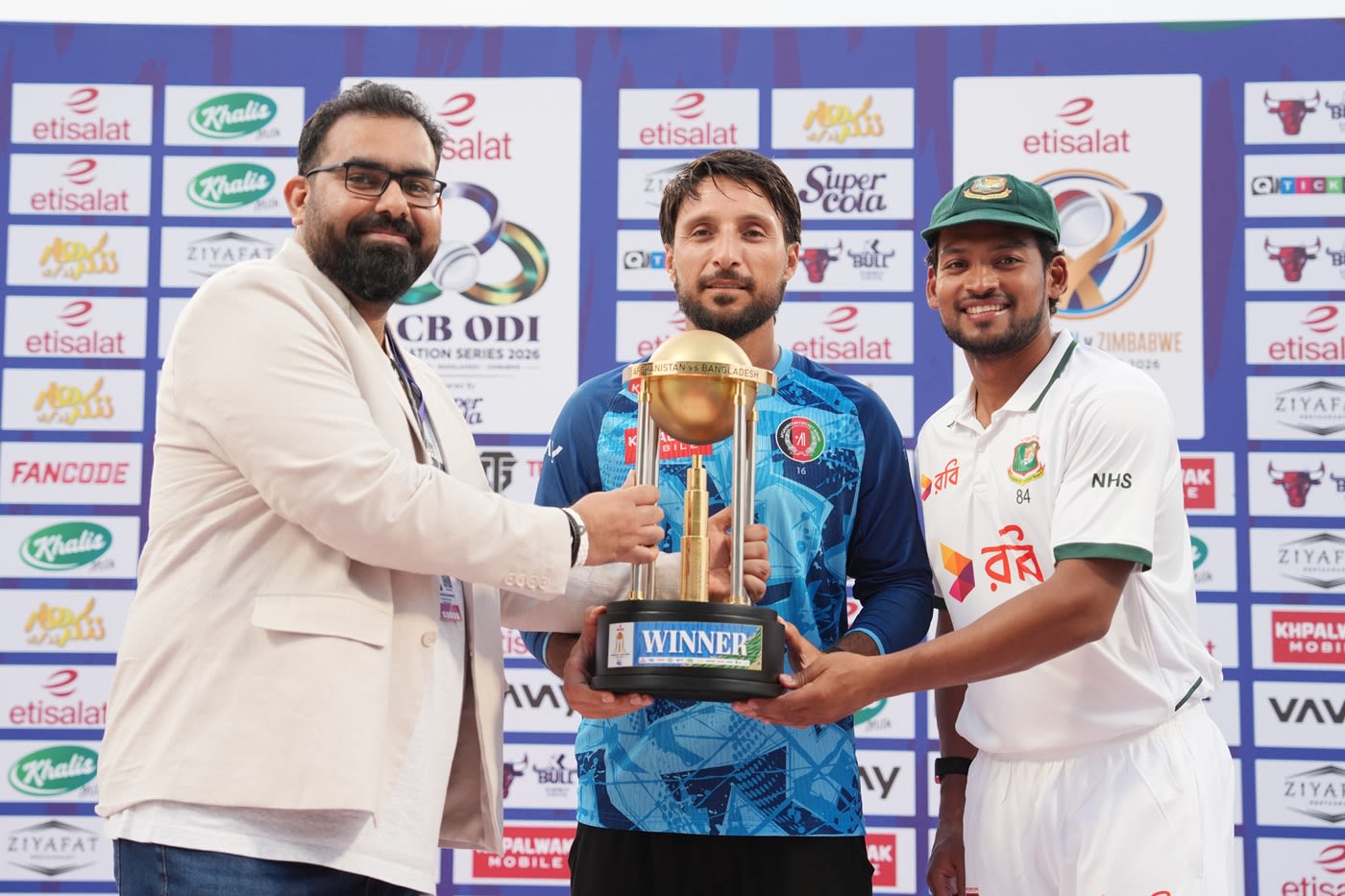 Captains Rahmat Shah and Najmul Hossain Shanto share the trophy