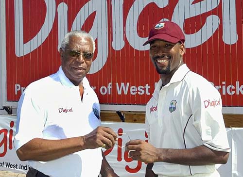 Lance Gibbs presents a gold bangle to Corey Collymore