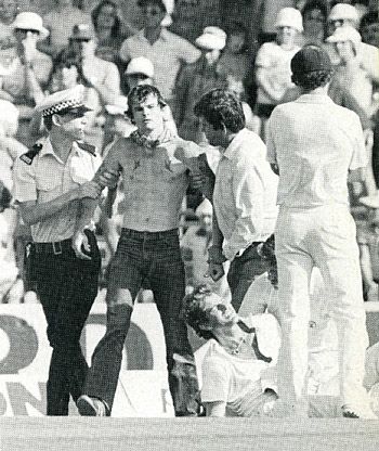 Police deal with the pitch invasion as Terry Alderman lies injured