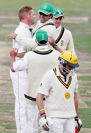 Shaun Pollock is congratulated by Justin Kemp after dismissing Clint Heron