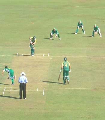 Craig Alexander bowls the first ball of the match