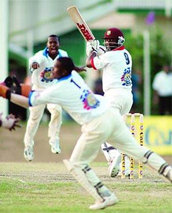 Brian Lara looks back as Patrick Browne grabs a brilliant catch