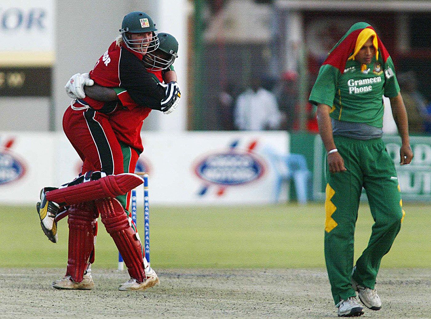 Brendan Taylor  and Blessing Mahwire celebrate as a dejected Mashrafe Mortaza trudges away