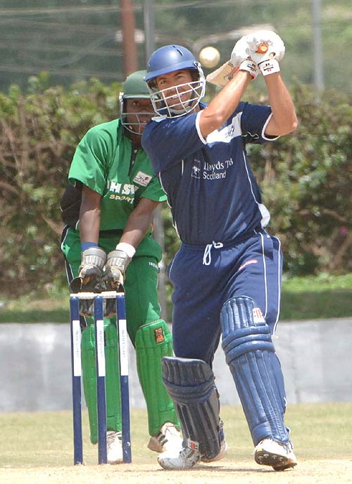 Scotland's Paul Hoffmann hits a six as Maurice Ouma looks on