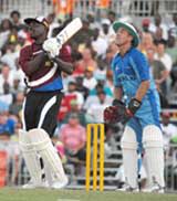 Collis King smashes a six as Alec Stewart watches on at the opening of the new Kensington Oval 