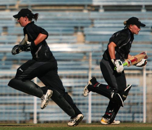 Maria Fahey (left) and Helen Watson of New Zealand cross over for a single