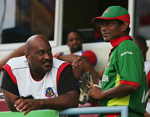 Dwayne Leverock and Mohammad Rafique chat during the rain