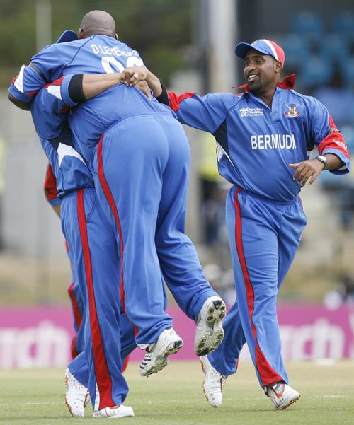 Dwayne Leverock is lifted off his feet by Irvine Romaine as Kwame Tucker looks on