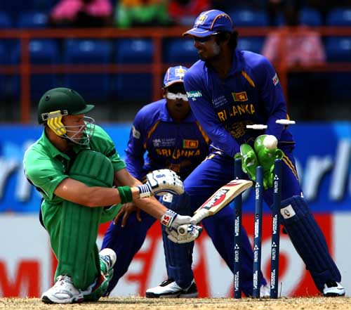Kenneth Carroll looks back to see his stumps displaced