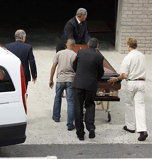 Workers unload the casket containing Bob Woolmer's body at Cape Town
