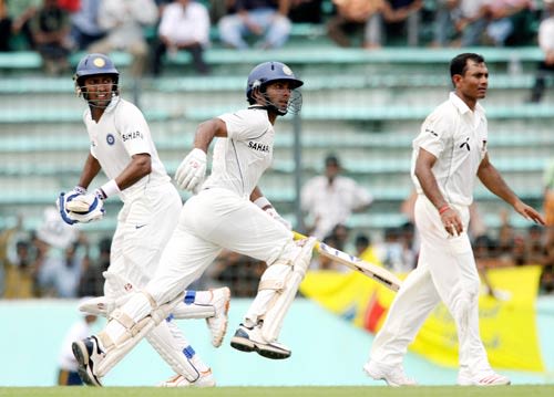 Wasim Jaffer and Dinesh Karthik go through for a single as Mohammad Sharif waits for the throw from the outfield