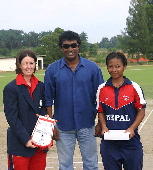 Hong Kong captain Neisha Pratt and Nepal captain Nary Thapa pose for pictures along with match referee Rumesh Ratnayake