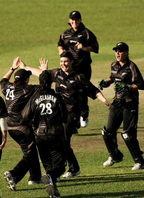 Sarah Tsukigawa is congratulated by her team-mates after picking up a wicket