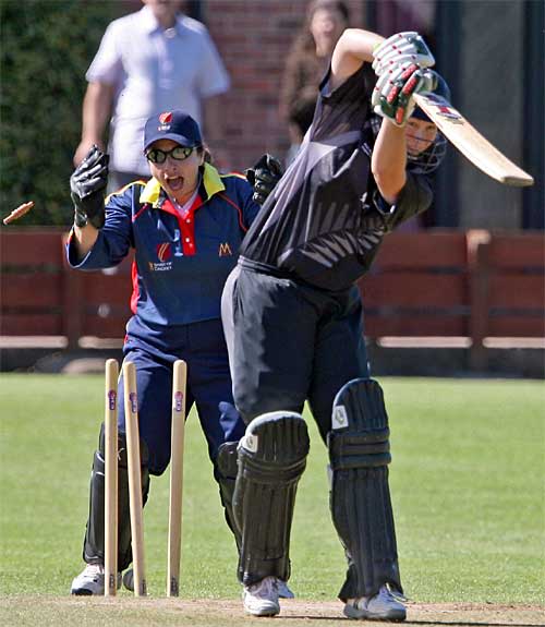 Aimee Mason is cleaned up by Hong Kong's Natasha Miles, playing for the MCC Invitational XI